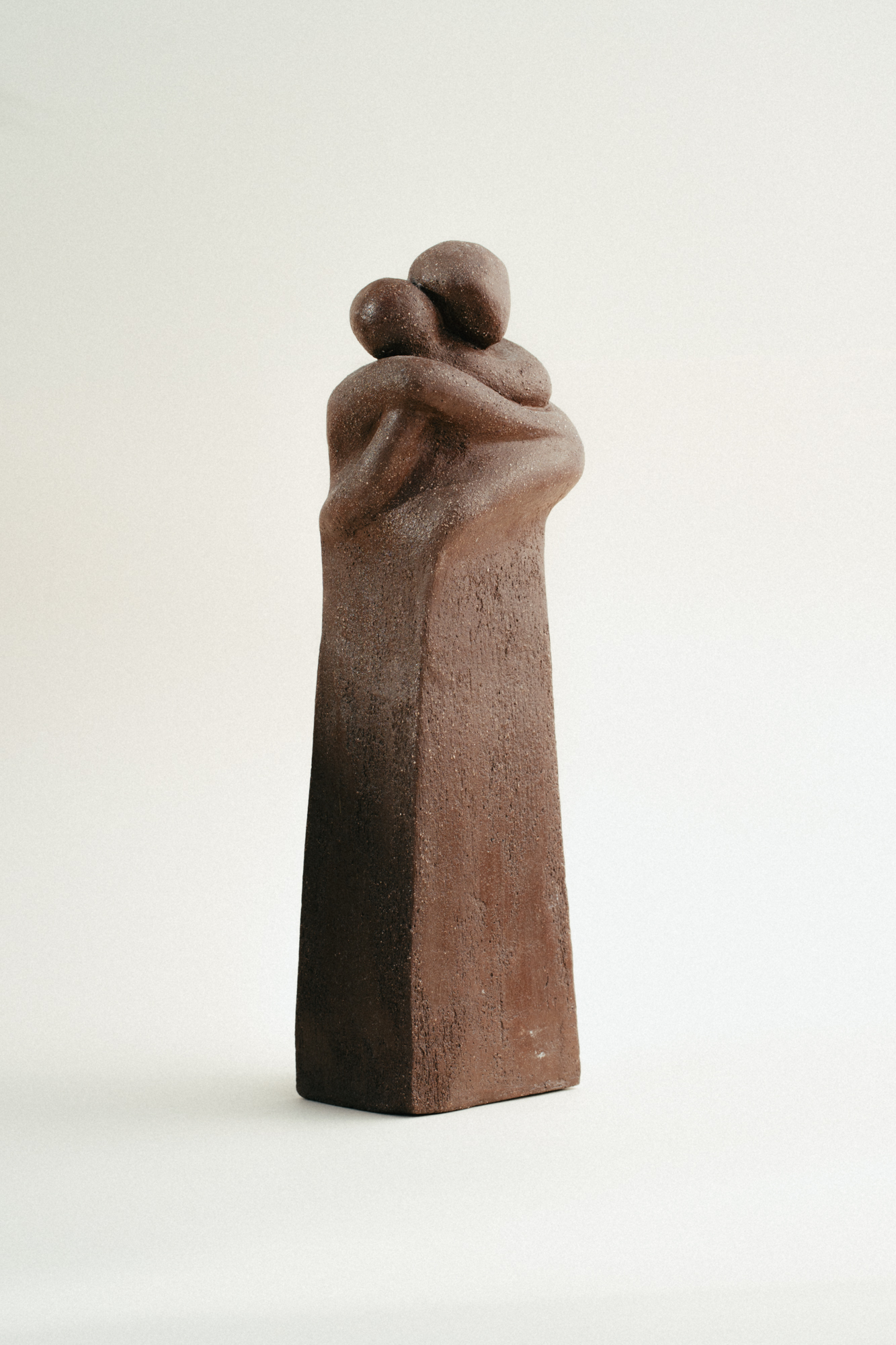 Dos figuras que se funden en un abrazo eterno, capturando la esencia de la intimidad humana y el consuelo que encontramos en el contacto con el otro.