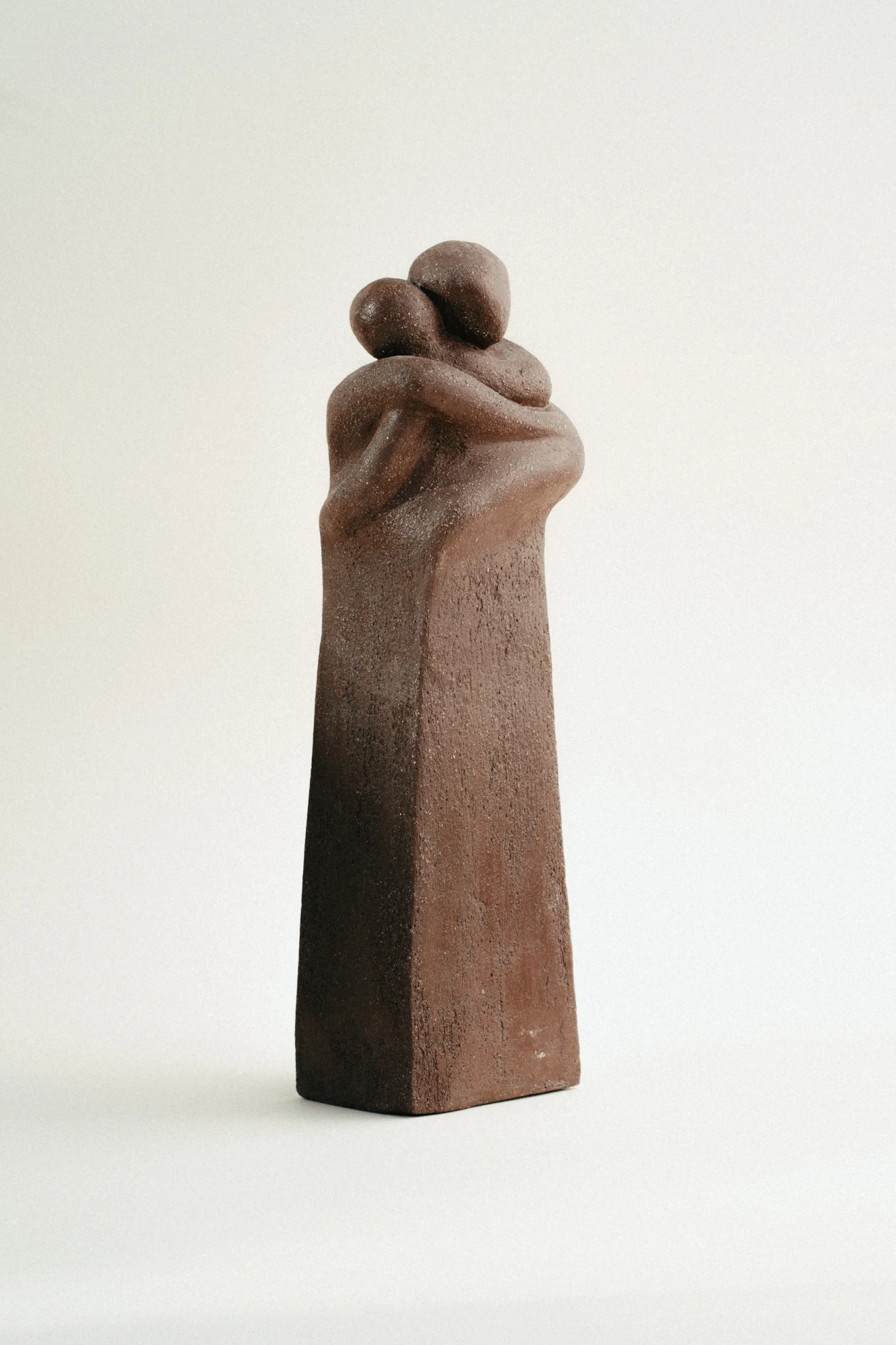 Dos figuras que se funden en un abrazo eterno, capturando la esencia de la intimidad humana y el consuelo que encontramos en el contacto con el otro.