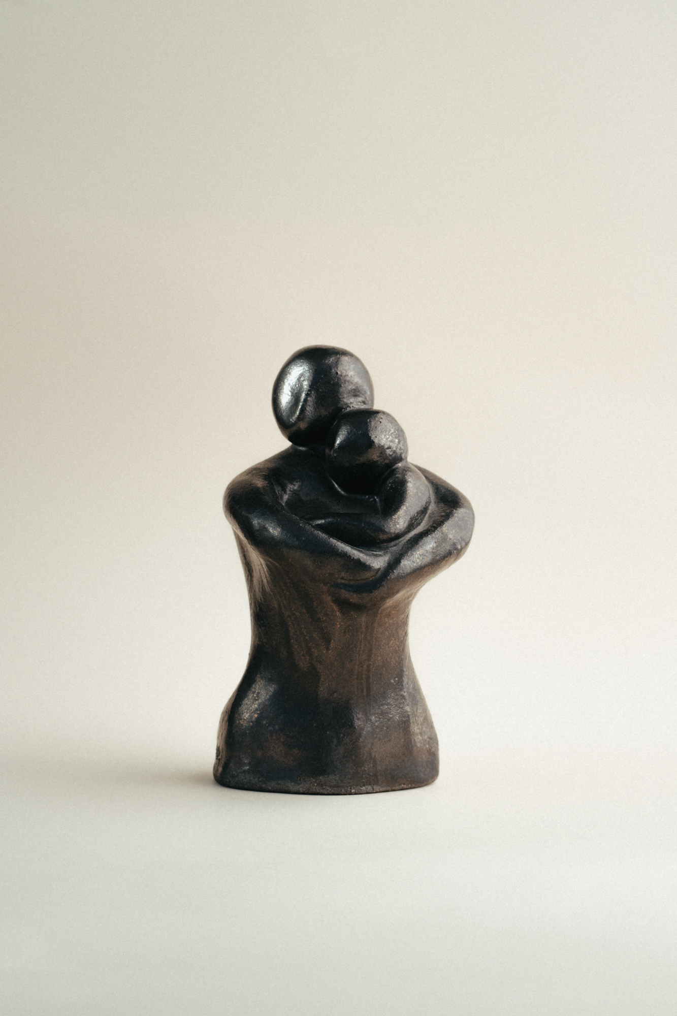 Representación conmovedora del vínculo maternal, donde la madre protege y acoge al hijo en sus brazos. Una pieza que celebra el amor incondicional y la ternura.